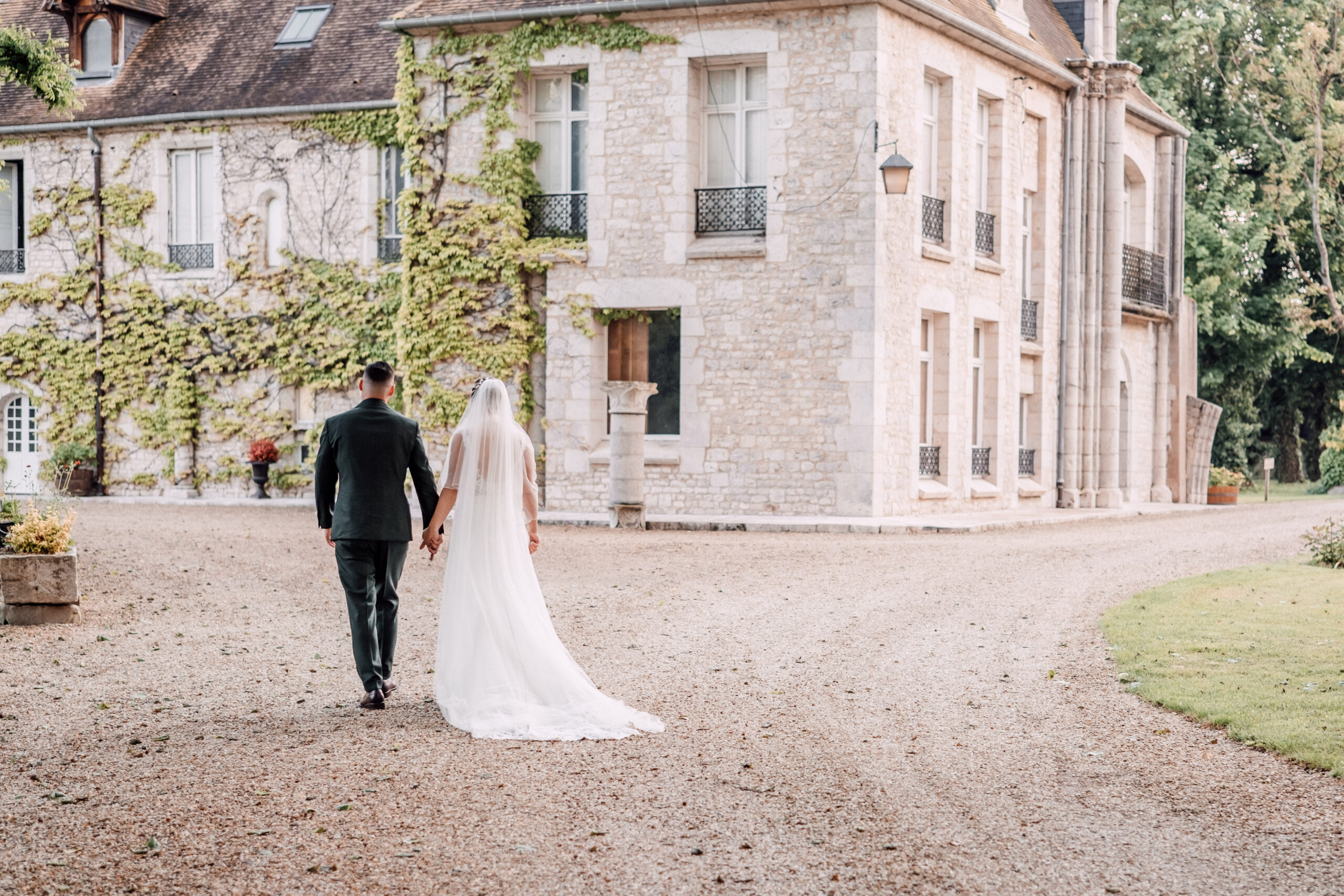 Les mariés marchent dans les jardins de l'Abbaye.